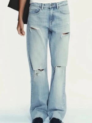 Ljusblå slitna raka jeans - Säljer ett par ljusblå jeans med  slitningar och hål på både lår och knän. Jeansen har klassisk femficksmodell och hög midja. Perfekta för en avslappnad och trendig look. Säljer pga att de inte längre passade mig. Längden passar någon som är ca 160 - 165 cm lång.