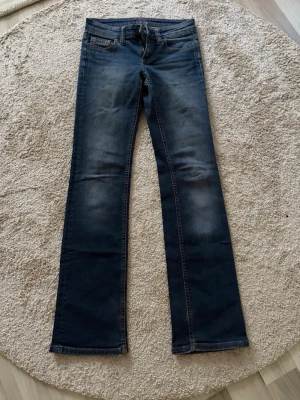 Mörkblå bootcut jeans med slitningar - Snygga mörkblå bootcut jeans med diskreta slitningar framtill och bakfickor med dekorativa sömmar. De sitter dock inte som 36 men 34!