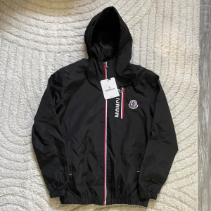 Moncler Vindjacka - Säljer en snygg och oanvänd vindjacka från Moncler. Fick som present men kom aldrig till någon användning därmed säljer jag den!