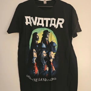 AVATAR band t-shirt med tryck - Svart t-shirt med stort Avatar-tryck fram och texten 'A New World Awaits' samt turnédatum bak. 