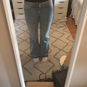 Bootcut jeans ljusblå från H&M Divided - Säljer ett par ljusblå bootcut jeans från H&M Divided i storlek 36. Jeansen har klassisk femficksdesign, normal passform. Materialet är mjukt denim och midjan är midwaist. Har sprättat upp där nere för att få dem längre 