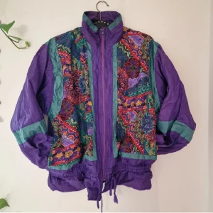 80s bomberjacka - BE the colorbomb(-er) this fall! Vintage bomberjacka med dragsko i nederkant, innertyg i mjukt bomull och 2 fickor fram. Denna har varit älskad och är väl omhändertagen. Pga flyttstäd behöver den tyvärr hitta ett nytt hem. Mått: Ärm - 60 cm, Axelbredd - 48 cm, Längd - 60 cm. Lila/grön med floral mönster. Återuppladdad för fri frakt. Jag har mycket annat uppe på sidan, både herr och damkläder. Köp gärna bundle för att få rabatt 🤗 