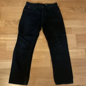 Svarta straight jeans från Zara - Svarta jeans från Zara i modellen Nordics Straight. Klassisk femficksdesign med knapp och dragkedja fram. Raka ben och normal passform, perfekta för en clean och stilren look. Materialet är jeans och färgen är djup svart.