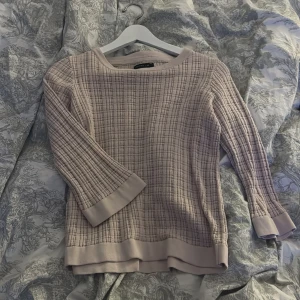 Beige stickad tröja från Stockh LM - Säljer en beige stickad tröja från Stockh LM i storlek XS. Tröjan har ett rutigt mönster, trekvartsärm och breda muddar vid ärmslut och nederkant. Perfekt för lager-på-lager och passar till både jeans och kjol.