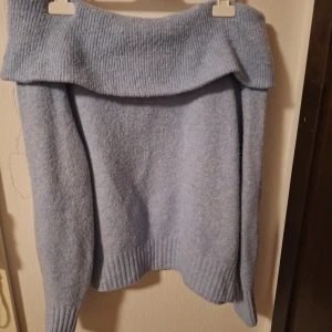 Ljusblå offshoulder stickad tröja H&M - Supermysig ljusblå stickad tröja från H&M i storlek S. Tröjan har en bred, ribbad offshoulder-krage och långa ärmar med ribbade muddar. Perfekt för dig som gillar chill och snygg stil med lite extra edge.