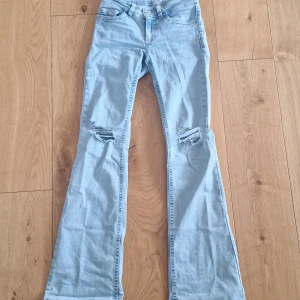 Bootcut jeans med slitningar från Nelly - Super snygga ljusblå jeans från Nelly i strl 34. Säljer då dom ej kommer till användning!