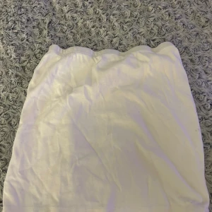 Vit kortkjol i bomull - Enkel och stilren vit kortkjol i mjukt bomullstyg. Kjolen har rak passform och resår i midjan för en bekväm känsla. Perfekt att matcha med en crop top eller hoodie för en chill look.