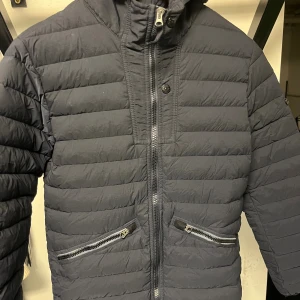 Stone Island jacka  - En stone Island junior dunjacka i storlek 14. Mycket fint skick men kompassen är tyvärr på rymmen.