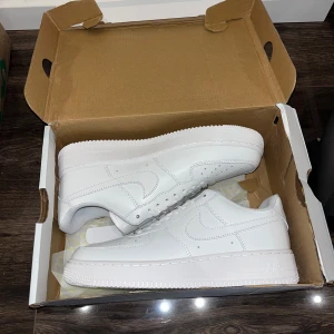 Nike Air Force 1  - Nike Air Force 1 - Vita (Helt nya)  Säljer ett par snygga och stilrena Nike Air Force 1 i  vitt. Skorna är helt nya, perfekt skick – inga repor, fläckar eller märken. Klassisk modell som passar till både vardag och festligare tillfällen. Storlek: 44 Vid intresse eller frågor är det bara att höra av sig!