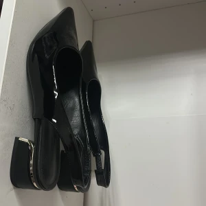 Svarta lack klackar SHEIN, strl 41 - Säljer ett par svarta pumps i lack med spetsig tå och bred klack med snygg metallisk detalj. Skorna har öppen häl med elastiskt band för bättre passform. Inte använd för stor storlek för mig‼️ 