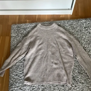 Beige stickad tröja från lager - Beige stickad tröja från lager med rund halsringning och ribbade muddar. Perfekt till hösten då den är varm. Långärmad och i en skön, lite loose passform som funkar till allt. Oanvänd då den ej passade mig!!
