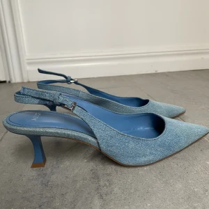Ljusblå denimklackar från MNG - Snygga ljusblå pumps från MNG i denim-look med spetsig tå och smal klack. Nypris: 529kr