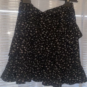 Svart blommig kjol - Svart blommig kjol storlek 164