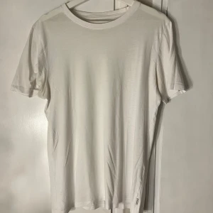 Vit t-shirt från Jack & Jones - En stilren vit t-shirt från Jack & Jones Essentials i storlek M. Klassisk rund halsringning och korta ärmar. Tillverkad i mjuk bomull för en skön känsla. Perfekt basplagg att matcha med allt.