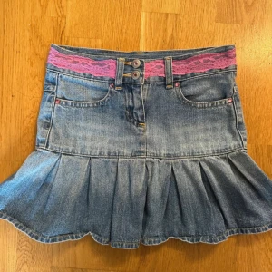 Jeansvolangkjol med rosa spets - Jättefin volangkjol med lågmidja, rosa spets och dina detaljer. 