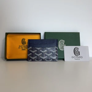 G yard korthållare i mörkblått mönster - Säljer en snygg korthållare från G i mörkblått med deras ikoniska grafiska mönster i vitt och brunt. Slimmad design med flera kortfack och klassisk G-logga framtill. Perfekt för dig som vill ha stilren och lyxig accessoar i fickan.