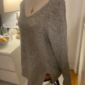 V-ringd HM tröja långärmad - Grå stickad långärmad tröja från H&M, i bra skick men knoppig som man kan se på bilden. Köpt i nypris för 199kr, säljer billigare pga skicket.  Storlek S🫶