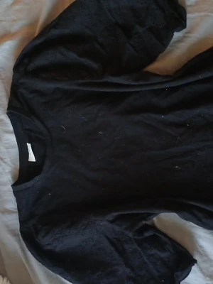 Svart blus med broderade puffärmar JDY - Säljer en svart blus från JDY i storlek XS. Toppen har puffiga långärmar med broderade detaljer och små hålmönster som ger en cool och unik look. Rund halsringning och mjukt bomullsmaterial. Perfekt för dig som gillar stilrena plagg med twist.