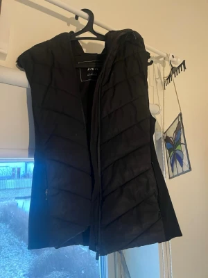 Zara väst  - Säljer en svart dunväst från ZARA i storlek S. Västen har ett quiltat mönster och dragkedja framtill samt fickor med dragkedja. Perfekt att slänga över en hoodie eller tröja när det är kyligt ute. Stilren och enkel design som funkar till många outfits.