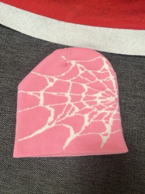 Rosa och vit Spider beanie - Trendig spinner mönstrad mössa i färgen rosa och vit