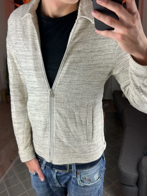 Stickad beige zip tröja  - Simpel och funkar perfekt till allt. Lite nopprig- bra skick. Skriv vid fundering. Mått:   A:53 B:43 C:42 D:61 (cm) 😊🙌