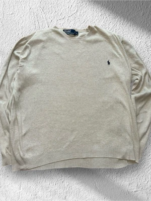 Beige Ralph Lauren Tröja Storlek L - Klassisk Ralph Lauren tröja i beige färg. Tröjan är i mycket bra skick men har tyvärr en väldigt liten fläck och ett super litet hål/reva vid nacken.  (Se sista 2 bilderna) |  Storlek: L | Skick:   Bra skick! | Tyvärr en liten fläck vid ena ärmen och ett mycket litet hål vid nacken. | Färg: Beige | Märke: Ralph Lauren | Modell: Sweatshirt, tröja  | Hör gärna av dig vid frågor så svarar jag så fort jag kan! 😁