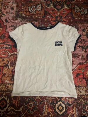 Vit t-shirt med blå detaljer - Vit t-shirt med mörkblå kant vid hals och ärmslut