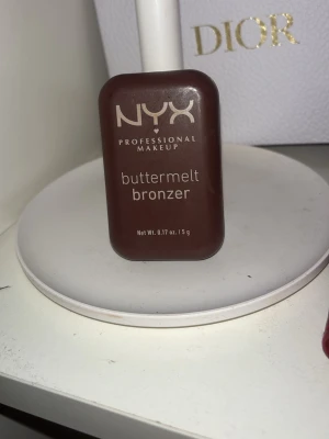 NYX Buttermelt Bronzer Butta Than U - NYX Buttermelt Bronzer i färgen Butta Than U, en djup och varm neutral ton. Kompakt brun förpackning med 5 g produkt. Krämig formula som ger en naturlig solkysst look. Perfekt för contouring och att framhäva ansiktets former. Säljs pga av att den var för mörk färg och gick inte att returnera, därav är den helt ny och oanvänd