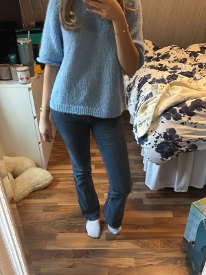 Mörkblå bootcut jeans  - Säljer ett par mörkblå jeans från Gina Tricot med klassisk bootcut-passform och hög midja. Jeansen har fem fickor, knapp och dragkedja framtill samt snygga sömmar. Materialet är slitstarkt denim i bomull och de sitter riktigt bra över höften och låren.