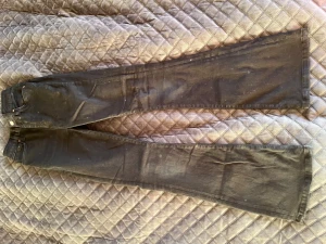 Svarta Peachy Flare jeans från Bik Bok - Säljer ett par svarta Peachy Flare jeans från Never Denim by Bik Bok. De har hög midja, utsvängda ben och klassisk femficksdesign. Materialet är en mix av bomull, polyester och elastan för en skön stretchig känsla. Bara använd någon enstaka gång. 