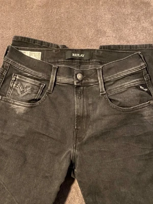 Replay Anbass jeans - Svarta Replay Anbass jeans i slim fit med klassisk femficksdesign och snygga detaljer vid fickorna. Jeansen är tillverkade i stretchigt jeansmaterial och har en modern, smal passform som sitter snyggt. Perfekta för dig som gillar stilrena och coola jeans.