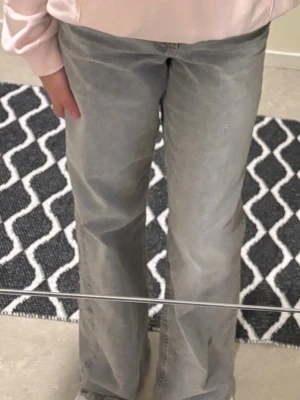 Gråa wide jeans - Säljer ett par gråa jeans med breda ben och klassisk femficksdesign. Jeansen har en rak och loose passform med normal midja. Materialet är slitstarkt denim i en snygg grå ton som passar till många olika stilar.