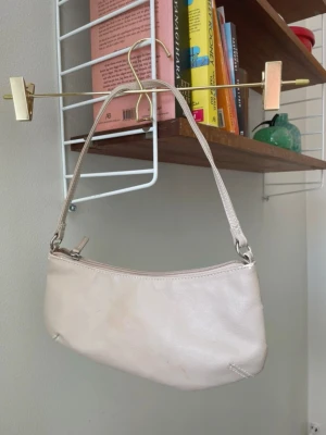 Axelväska / handväska  - Axelväska från H&M. Använt skick, lite sprucken på remmen och längs dragkedja samt lite fläckig.