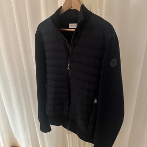 Moncler Cardigan Marinblå - Säljer denna Moncler Cardigan i färgen marinblå. Storlek L (sitter lite mindre, funkar på M) och är i väldigt fint och bra skick. Inga defekter eller liknande då jackan har tagits hand om väl. Bild 4 ser ni även kvitto samt tags och denna jacka är köpt i butik som ni även ser på kvitto. Hör av dig vid fler frågor eller annat😉🙏🔥
