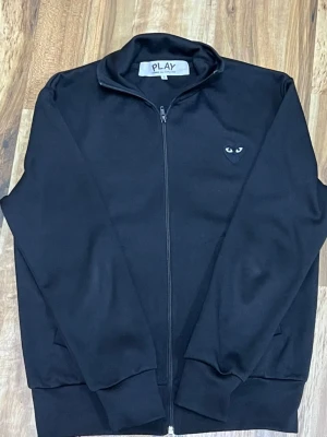 Svart zip hoodie Comme des Garçons Play - Svart Comme des Garçons tröja i storleken S. Den är använd ett par gånger men är I fint skick. Meddela gärna om du är intresserad 