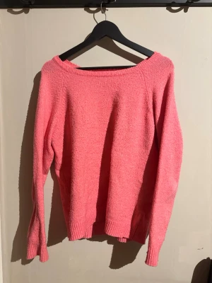 Rosa stickad tröja från Amisu - Mysig rosa stickad tröja från Amisu i storlek M. Tröjan har en bred rund halsringning och långa ärmar. Materialet är stickat och känns mjukt mot huden. Perfekt för att hålla sig varm under kyliga dagar.