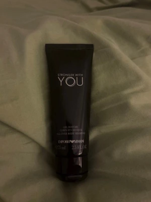 Emporio Armani Stronger With You - All over body schampo - Emporio Armani Stronger With You all - over body shampoo i en svart tub på 75 ml som inte är använd. Tuben har stilren design med vit text och är perfekt för både kropp och hår. Lyxig känsla och passar dig som gillar exklusiva dofter. Passar perfekt till en swy parfym! Säljer för att jag inte är så förtjust i dens lilla förpackning, OBS låda kommer inte med!!