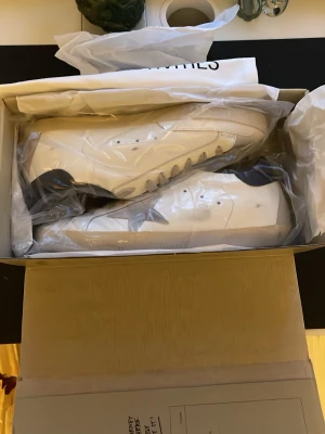 Vit sneakers från Golden Goose - Golden Goose sneakers i helvit färg med rund tå och platt sula. Skorna har klassisk snörning och är tillverkade i skinn. Kommer i originalkartong med dustbag med tryck. Perfekt för dig som gillar minimalistisk och clean stil.