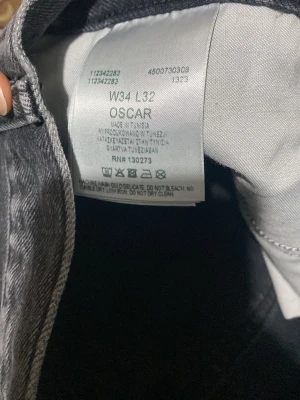 Mörkblå jeansbyxor Oscar W34 L32 - Snygga mörkblå jeansbyxor från Oscar i klassisk rak modell. Jeansen har fem fickor och subtil tvätt för en avslappnad look. Tillverkade i slitstarkt denimtyg som passar perfekt till vardags. Midjan är normal och benen har en rak passform.