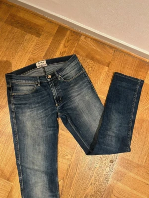 Mörkblå jeans från Acne Studios - Snygga mörkblå jeans från Acne Studios med klassisk femficksdesign och subtila slitningar. Modellen har normal passform och raka ben, perfekt för dig som gillar en stilren look. Materialet är slitstarkt jeans och färgen har en cool tvättad effekt.