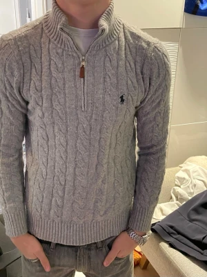 Grå stickad half-zip från Polo Ralph Lauren - Säljer en riktigt skön halv zip från Ralph Lauren. Sparsamt använd, storlek M. Hör av er vid frågor!