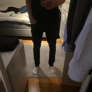 Svarta tiger of Sweden jeans  - Svarta jeans med klassisk femficksdesign. Jeansen har normal midja och är tillverkade i stretchigt denimtyg för extra komfort. Perfekta för dig som gillar en stilren och modern look. Storlek 32/34.