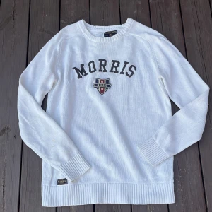 Vit stickad tröja från Morris Gents - Vit stickad tröja från Morris Gents med broderad logga och text på bröstet. Tröjan har rund hals, långa ärmar och breda ribbade muddar vid ärmslut och nederkant. Perfekt för en clean och klassisk stil. Har en liten fläck på ena armen, men inga andra defekter. Pris kan diskuteras ✅😁