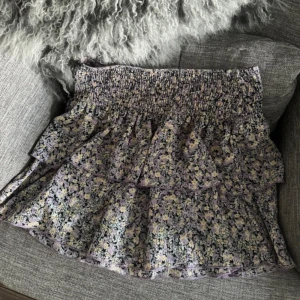 Kjol  - Blommig volang kjol med högmidja från Gina tricot i storlek 38. 