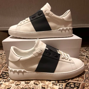 Valentino Garavani Open - Snygga Valentino Garavani Open sneakers i vit skinn. Skorna är relativt nya och använda endast en gång och ser helt nya ut. Mer bilder kan fås vid behov och pris är inte hugget i sten så KOM MED BUD!!!!