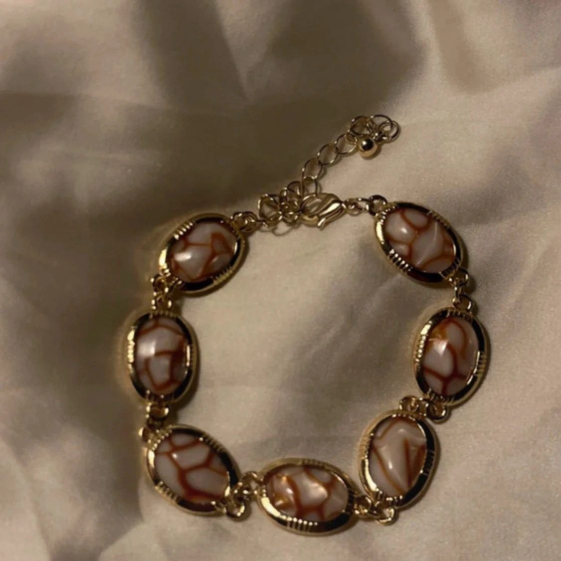 Guldigt armband med marmorerade länkar