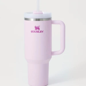 Stanley Quencher H2.0 FlowState Tumbler 40oz Pastel Pink - Stanley Quencher H2.0 FlowState Tumbler i pastellrosa, 40oz. Utrustad med handtag, lock och sugrör. Perfekt för kalla och varma drycker. Produkten ser ut att vara i nyskick utan synligt slitage eller defekter. Modern design och hög kvalitet.