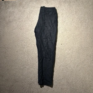 Svarta linne-byxor från J.Lindeberg stl 46 - Snygga svarta linnebyxor från J.Lindeberg i storlek 46. Byxorna har en rak passform med elastisk midja och diskreta fickor. Perfekt för dig som gillar stilrena och klassiska plagg med modern touch.