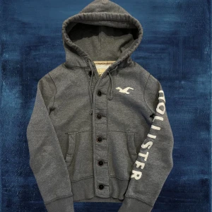 Hollister Hoodie - Säljer nu denna väldigt trendiga och coola hoodien från Hollister. I väldigt bra skick, inga deffekter. Modellen är 175, 59kg. Skriv vid frågor!