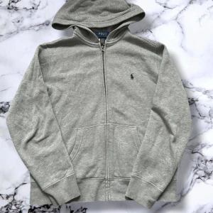 Ralph lauren zip hoodie - Ralph Lauren Zip Hoodie 👕✨  🩶 Färg: Grå 📏 Storlek: XXS ⭐ Skick: Väldigt fint skick, knappt använd! 📦 Leverans: Skickas inom 24 timmar 🚀 💬 Pris: Kan diskuteras 💸